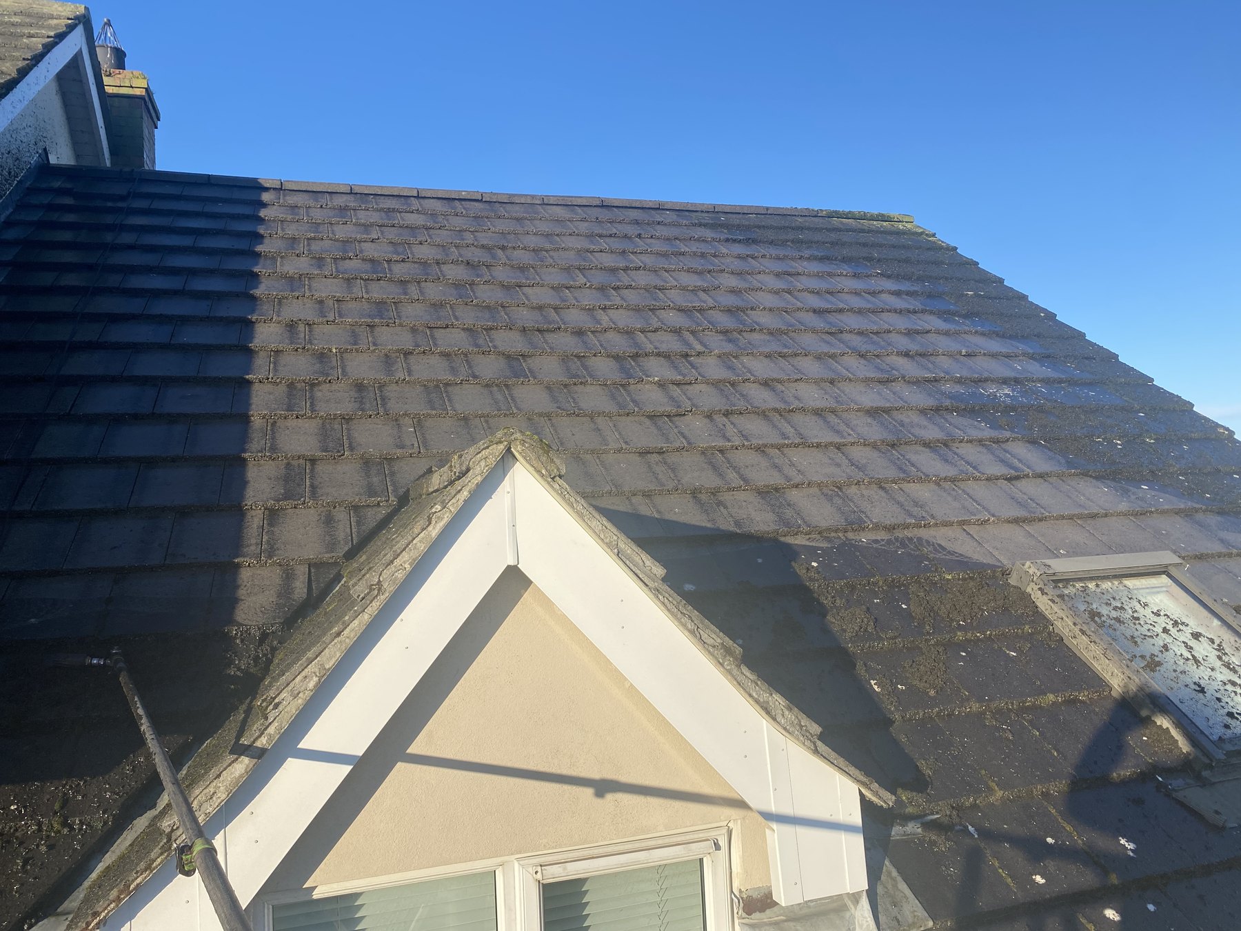 Slate roof before cleaning under clear blue sky