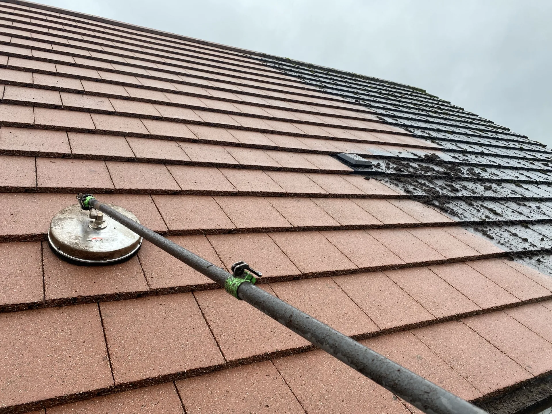 Roof cleaning in progress on a tiled roof