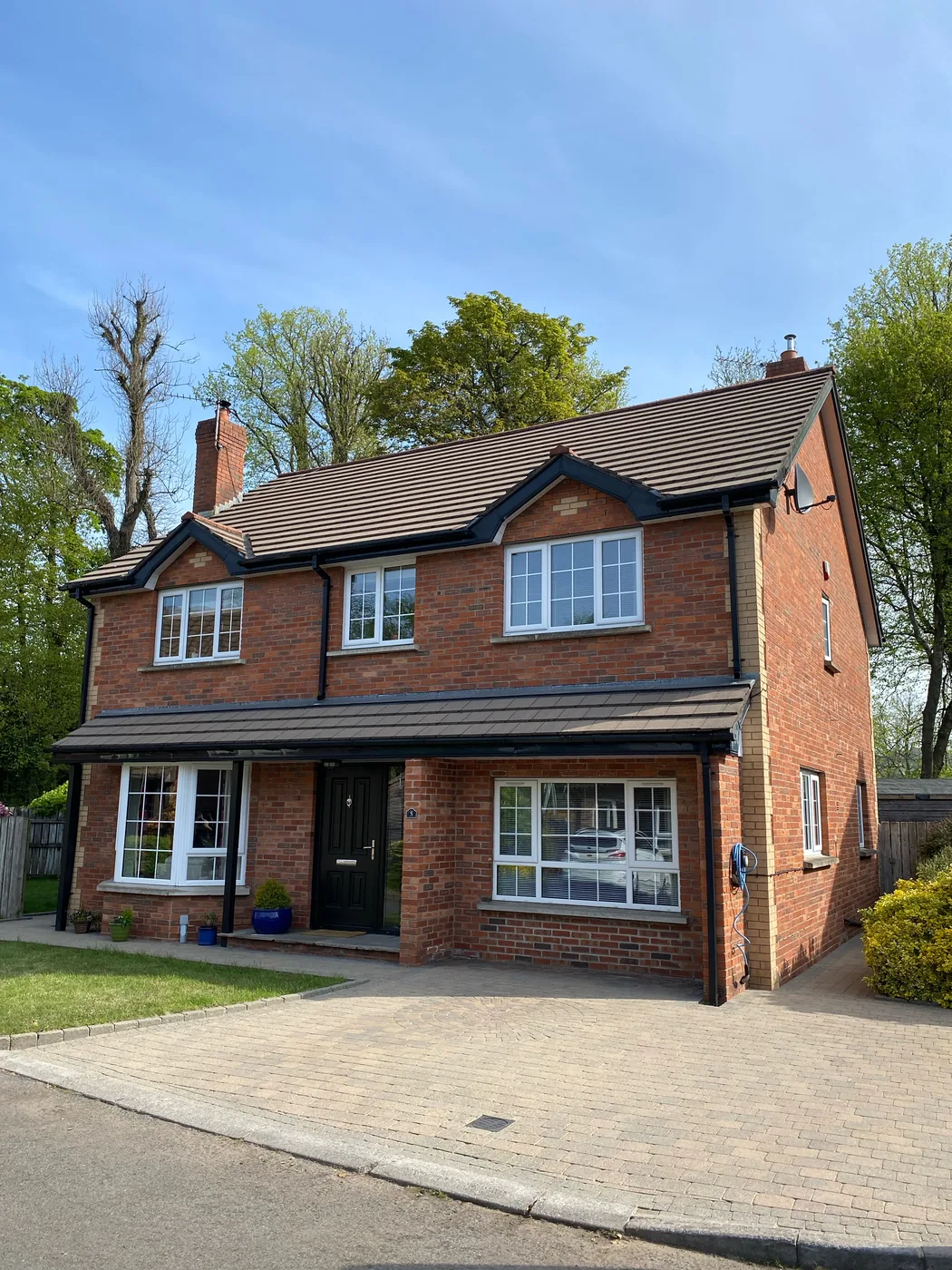 Full home exterior after a roof-to-drive clean and algae treatment