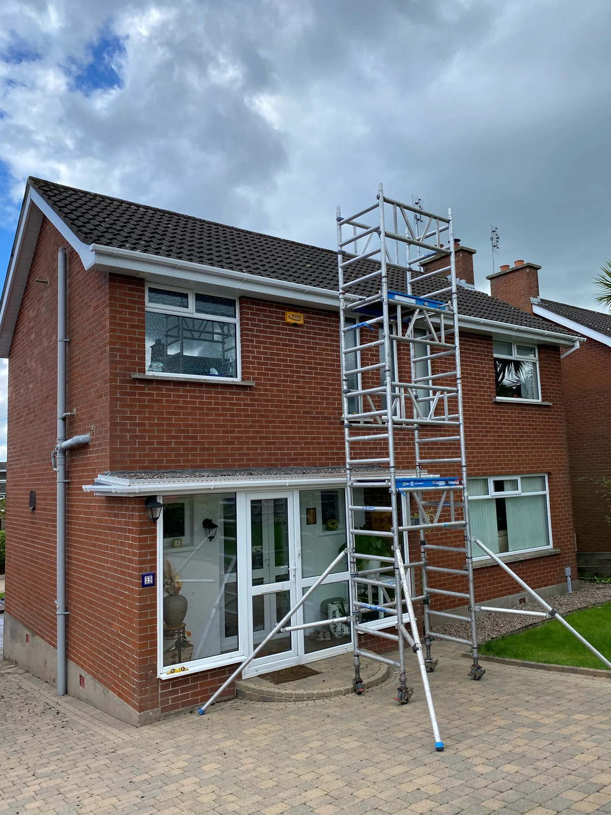 CleanCoat tower scaffold set up beside a house for roof cleaning access