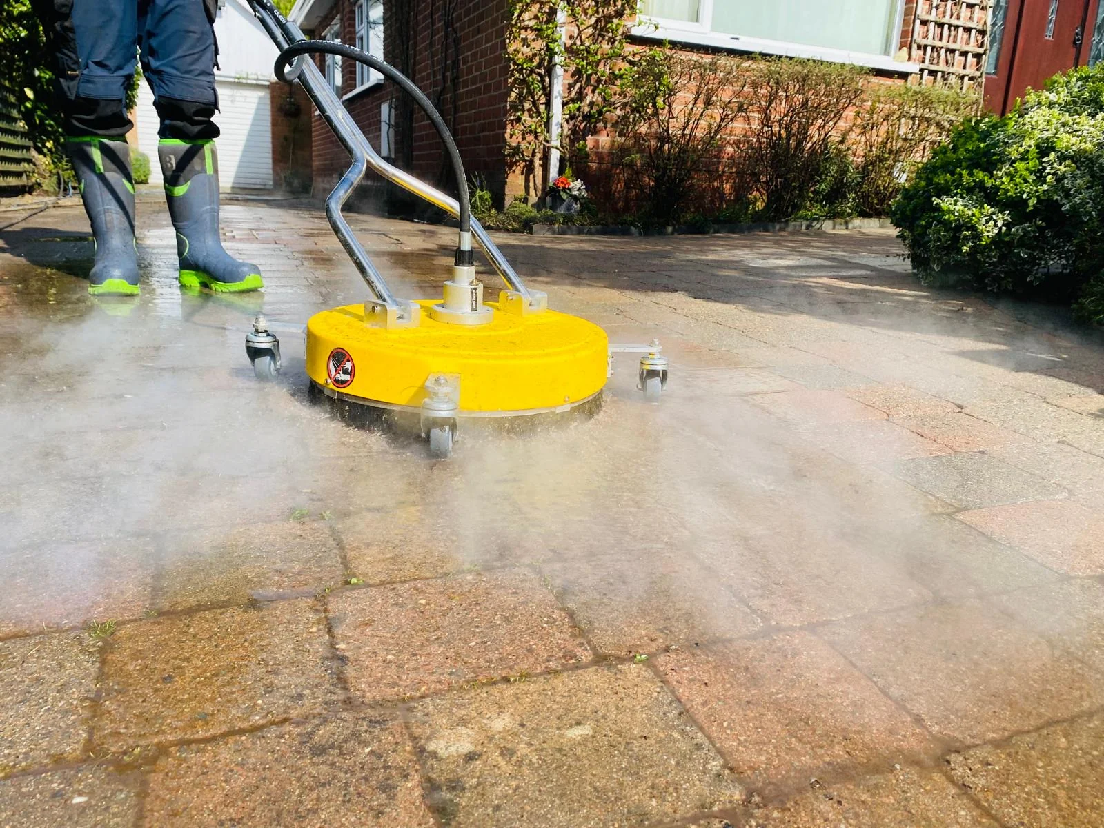 Steam-cleaning equipment in action on a paved exterior surface